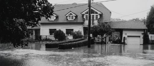 Huis met straat die overstroomd is door noodweer