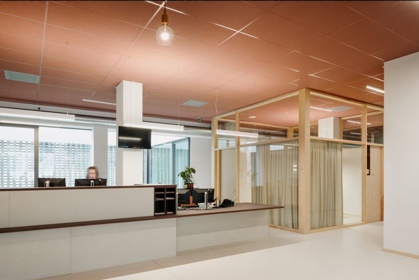 onthaal met onderrijdbare balie en aparte gesprekruimte met aandacht voor visuele en auditieve privacy